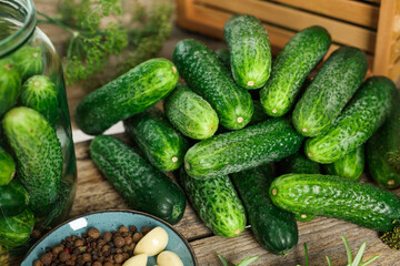 Pile of fresh cucumbers and spices on wooden table, closeup. Preparation for pickling