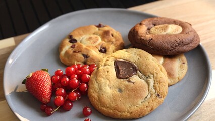 Biscuits on grey plate offer simple comforting breakfast With fresh berries and warm cup of tea this setup embodies cozy laid-back vibe of easy morning For those who appreciate beauty in simplicity