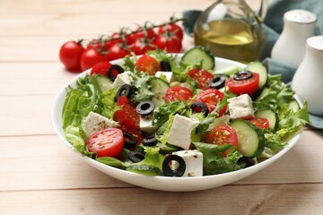 Delicious salad with feta cheese on white wooden table, closeup
