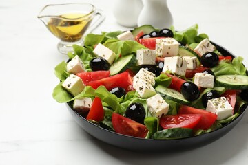 Delicious salad with feta cheese served on white marble table, closeup