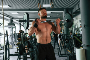 Muscular strong man is working out in the gym