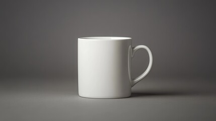 Obraz premium An empty white porcelain drinking cup is displayed from the front against a gray backdrop. The mug is devoid of any design or decoration, exhibiting a minimalist and elegant aesthetic.