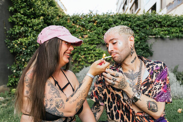 Woman lighting man's cigarette in playful outdoor scene