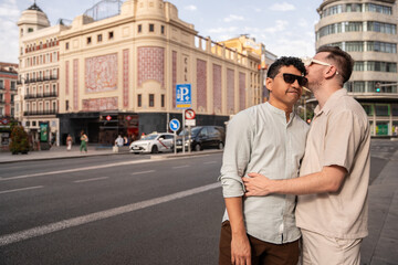 Affectionate multiethnic gay couple embracing in a bustling cityscape