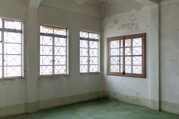 Obraz premium Spacious interior with weathered walls and large windows, providing natural light and an airy atmosphere.