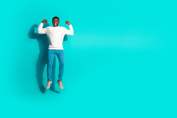 Fototapeta premium Full length photo of handsome young guy jump flexing show muscles dressed stylish white garment isolated on cyan color background