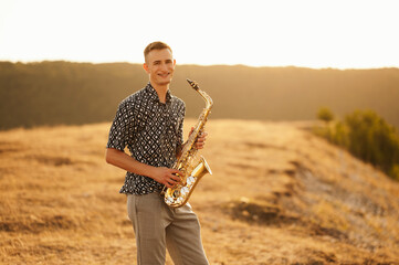 A remarkably talented young saxophonist is enjoying a peaceful and serene sunset on a beautiful...