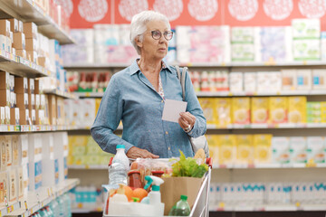 Confused elderly woman buying groceries at the supermarket