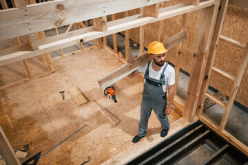 In yellow hardhat. Industrial worker in wooden warehouse