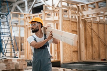 Fototapeta premium The wooden plank. Industrial worker in warehouse