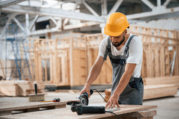 By the table. Industrial worker in wooden warehouse