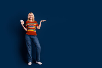 Photo of nice cheerful lovely woman wear trendy clothes recommend novelty empty space isolated on dark blue color background