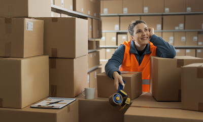 Happy warehouse worker having a break and thinking