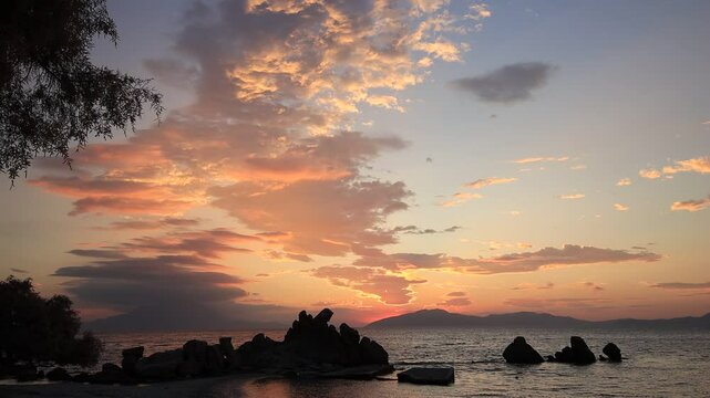 Gorgeous view of an epic sunrise over Fourni island from Kerame beach on the beutiful greek island of Ikaria.