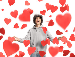 Excited guy in a looking up at red falling hearts