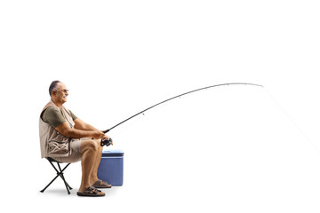 Full length profile shot of a fisherman sitting and catching fish