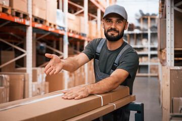 In cap, with boxes. Foreman is in the storehouse, shipping distribution business