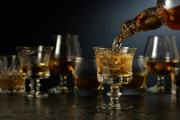 Whiskey is poured from a bottle into a glass.