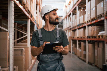 Quality control, with notepad. Foreman is in the storehouse, shipping distribution business