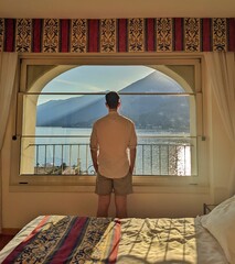 A beautiful sunset view over Lake Como from a hotel room, highlighting the lake's golden hues