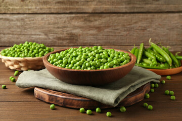 Fresh green peas and pods on wooden table