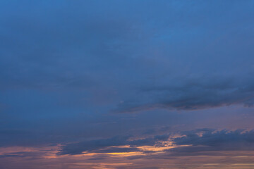 Obraz premium Golden hues paint the sky as fluffy clouds dance with the setting sun