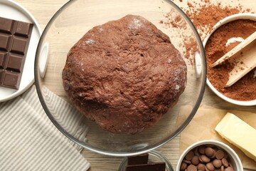 Chocolate dough and ingredients on wooden table, flat lay