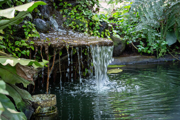 Waterflow from the rocks in a garden-style restaurant, similar to a mini waterfall