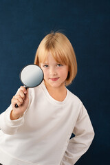 A blonde girl is photographed for a school album in a studio with a movie camera