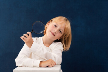 A blonde girl is photographed for a school album in a studio with a movie camera