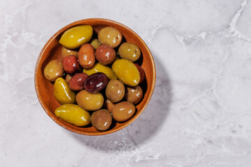 An assortment of various olives presented in a bowl, showcasing different colors, textures, and flavors