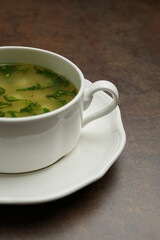 Azerbaijan dushbara soup in a white bowl. Dumplings soup with herbs