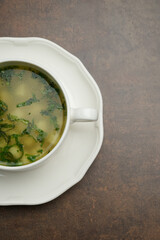 Azerbaijan dushbara soup in a white bowl. Dumplings soup with herbs
