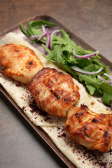 Grilled chicken on skewer served on tray, close-up