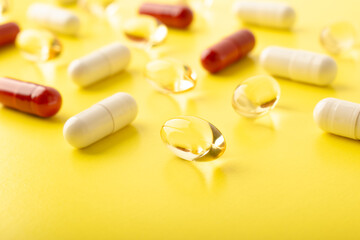 Pills. Supplements omega 3, vtamin C. White pills, red capsules on yellow background. An allergy pill, antibiotics. Medicine, healthcare concept. Virus(viral) and flu diseases. High quality photo