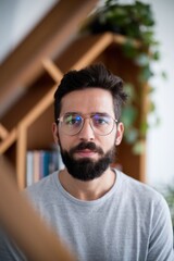 Obraz premium Portrait of a Man with Glasses in a Cozy Home Setting