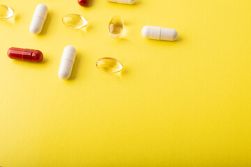 Pills. Supplements omega 3, vtamin C. White pills, red capsules on yellow background. An allergy pill, antibiotics. Medicine, healthcare concept. Virus(viral) and flu diseases. High quality photo