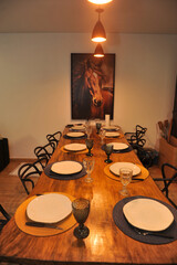 mesa rustica arrumada para jantar com quadro de cavalo ao fundo 