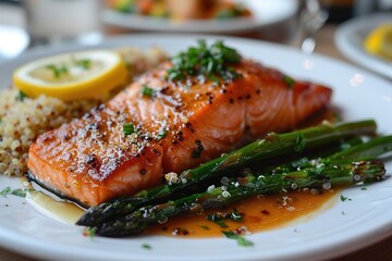 A plate of salmon and asparagus with a lemon wedge on top