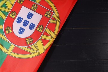 A close-up view of the Portuguese flag showcasing its vibrant colors and distinct design on a textured dark surface