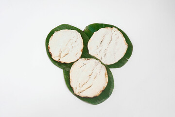 Original Serabi or surabi traditional cake. Indonesian traditional food made from rice flour mixed coconut brown sugar. On plate and green banana leaf isolated on white background