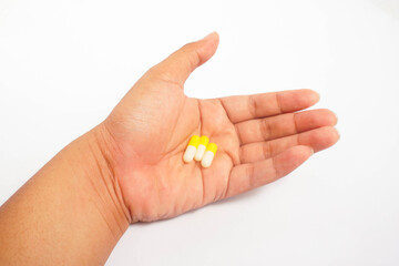 a man consuming three yellow capsules with white isolated