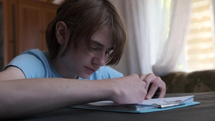 Young man completely absorbed in his art, carefully drawing on a piece of paper at his home workspace