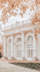 Fototapeta premium On a beautiful sunny day, a small white pavilion stands amid vibrant autumn trees, inviting visitors along a cobblestone path through the colorful landscape