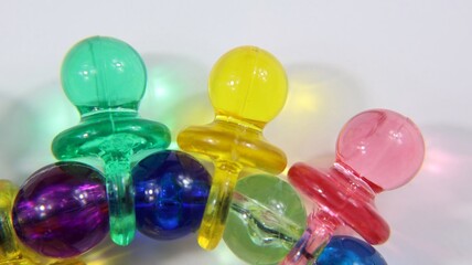 Focus on first floor toy necklace colorful plastic pacifiers with copy space