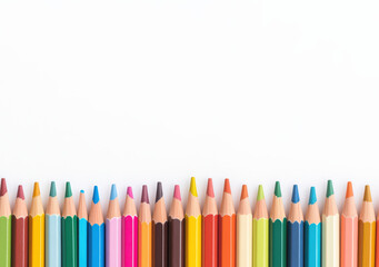 Fototapeta premium Colorful pencils with sharpened tips arranged in a neat row against a white background, representing creativity and art.