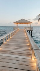 Obraz premium A wooden bridge connects to a traditional thatched hut on an island as the sun sets, casting a warm glow over the turquoise ocean and purple clouds