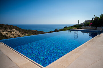 A beautiful pool at a house in a summer landscape, with a sea view in the distance.