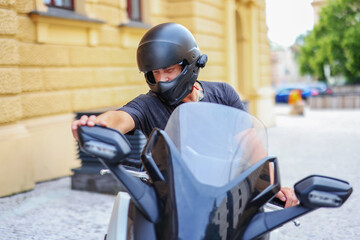 man fastens a black helmet on his head