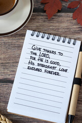 Christian handwritten quote in notebook for giving thanks to the LORD with coffee cup and autumn...
